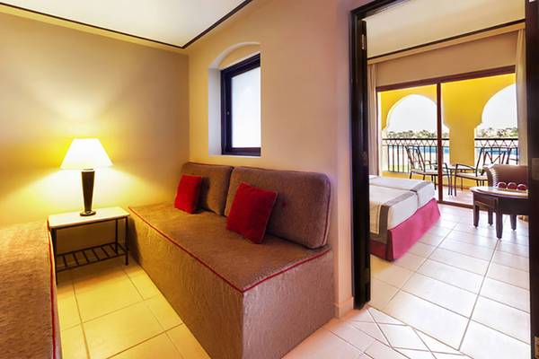 Innenansicht der Suite im Jaz Samaya Resort mit Sofa, Tischlampe und Schlafzimmer