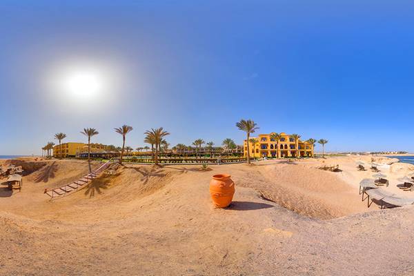 Jaz Samaya Resort Strandansicht mit Gebäuden, Palmen und einem großen Wasserkrug