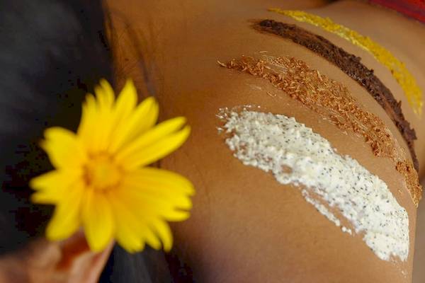 Spa-Behandlung im Kuredu Island Resort & Spa mit einer gelben Blume und verschiedenen Hautpflegeprodukten.