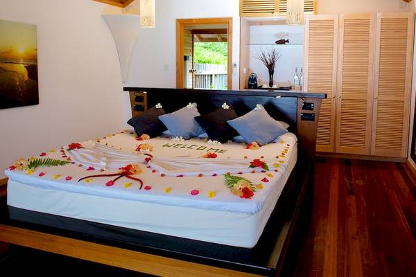 Hotelzimmer im Kuredu Island Resort & Spa mit einem großen Bett, das mit Blumen dekoriert ist.