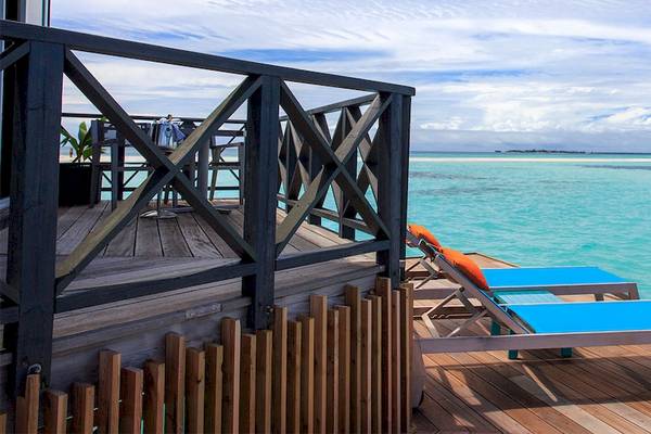 Poolseite-Lounge mit zwei blauen Liegen und einem Tisch im Kuredu Island Resort & Spa
