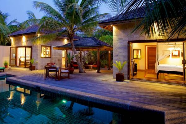 Außenbereich des Kuredu Island Resort & Spa mit Pool, Loungestühlen und Pavillon.