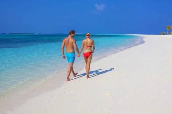 Paar am Strand des Kuredu Island Resort & Spa