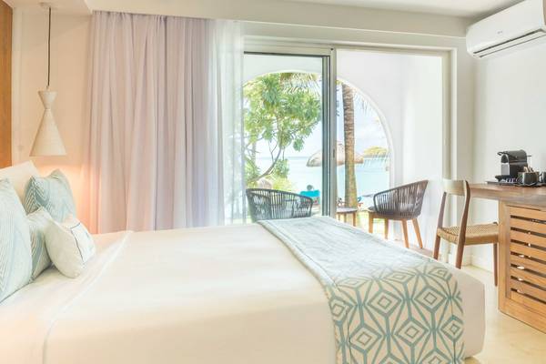 Innenansicht eines Schlafzimmers im Seasense Boutique Hotel mit Blick auf das Meer