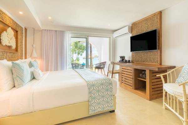 Schlafzimmer im Seasense Boutique Hotel & Spa mit großem Bett, Fernseher, Klimaanlage und offenem Balkon.
