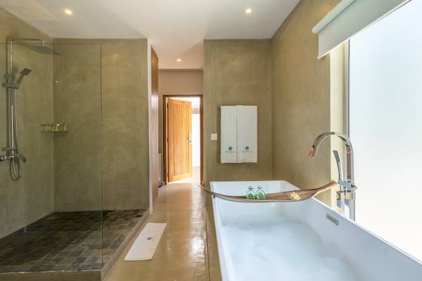 Badezimmer im Seasense Boutique Hotel & Spa mit Badewanne, Dusche und Fenstern.