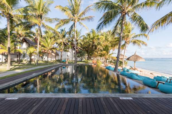 Poolbereich im Seasense Boutique Hotel & Spa mit Palmen und Strandliegen.