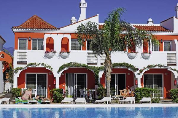 Außenbereich des Bungalows Cordial Green Golf Hotels mit roten und weißen Gebäuden und Pool.