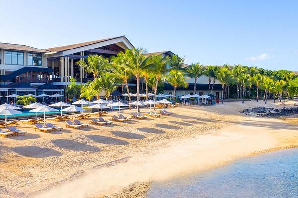 Außenbereich des InterContinental Resort Mauritius mit Strand, Palmen und Sonnenliegen