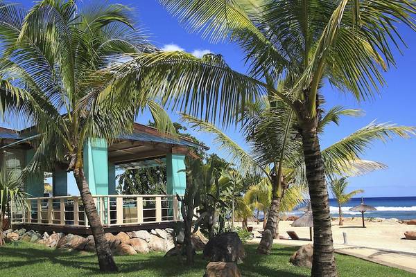 Außenbereich des InterContinental Resorts Mauritius mit Strandhütte und Palmen.