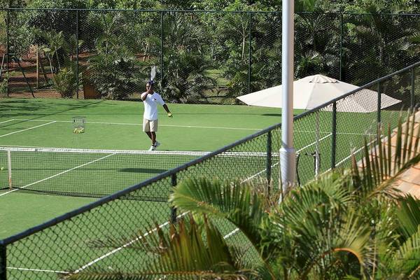 Tennisplatz im InterContinental Resort Mauritius mit einem Spieler, der bereit ist zu spielen.