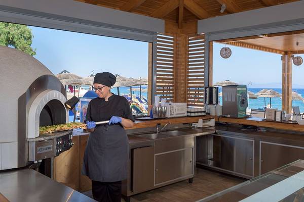 Koch im Avra Beach Resort Hotel bereitet eine Mahlzeit im Ofen zu.