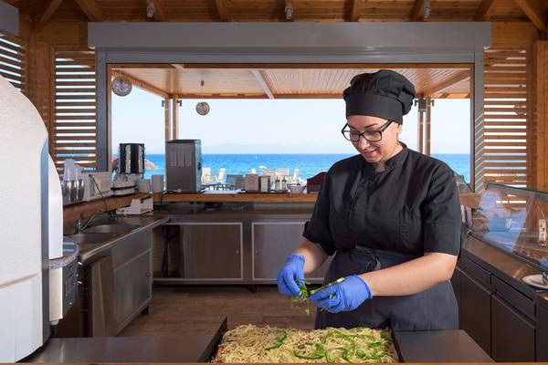 Köchin im Avra Beach Resort Hotel & Bungalows, die eine Mahlzeit zubereitet