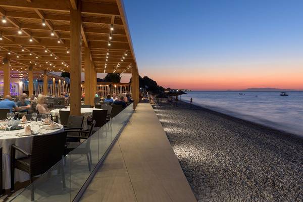 Terrasse des Avra Beach Resort Hotels mit Blick auf den Ozean bei Sonnenuntergang