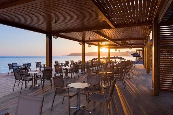 Terrasse des Avra Beach Resort Hotels bei Sonnenuntergang mit Blick auf das Meer
