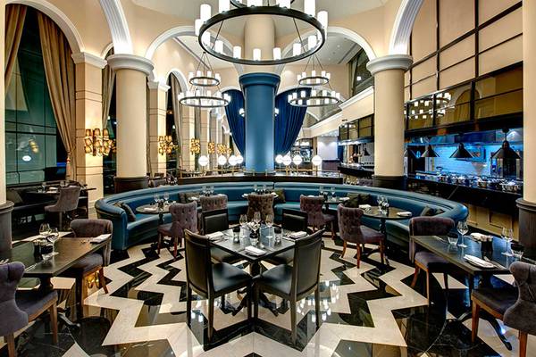 Innenansicht des Restaurants im Dukes The Palm, einem Royal Hideaway Hotel mit blauen Möbeln und schwarzen Marmorböden.
