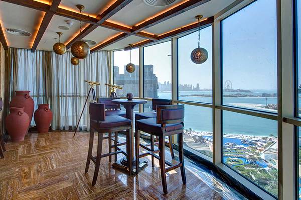 Innenansicht eines eleganten Hotelbereichs mit Blick auf das Meer und der Skyline der Stadt.