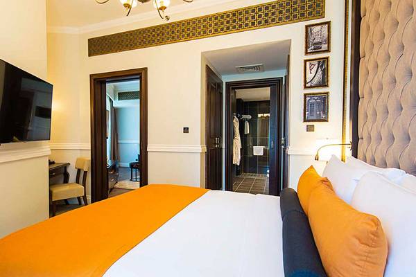 Ein modernes Zimmer im Dukes The Palm, a Royal Hideaway Hotel mit einem großen Bett, Fernseher und bequemen Möbeln.