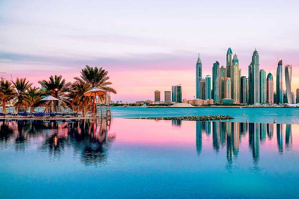 Stadtsilhouette von Dubai am Abend mit reflektierten Hochhäusern im Wasser