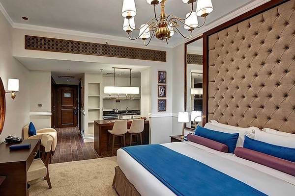 Innenansicht eines Zimmers im Dukes The Palm, a Royal Hideaway Hotel mit Bett, Schreibtisch und Wohnzimmermöbeln.