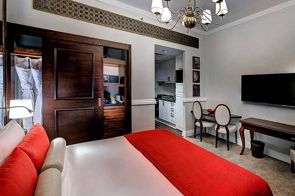 Innenansicht der Suite im Dukes The Palm, einem Royal Hideaway Hotel mit Bett, Schreibtisch und Fernseher.