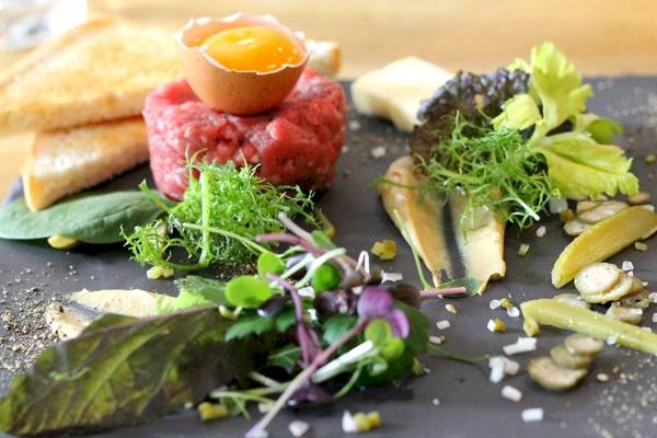 Frühstücksplatte mit Rindertatar, Spiegelei, Toast und Salat im Hotel Zeitgeist Vienna Hauptbahnhof.