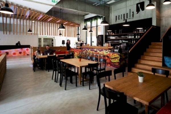 Innenansicht des Restaurants im Hotel Zeitgeist Vienna Hauptbahnhof mit Tischen, Stühlen und einer Theke.
