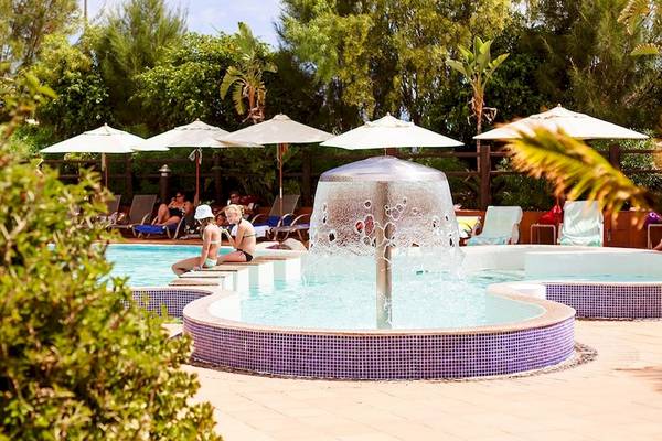 Pool im IFA Altamarena Hotel mit umliegenden Sonnenschirmen und relaxenden Gästen.
