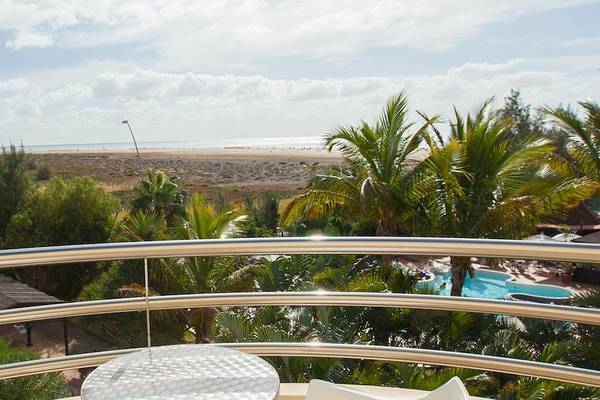 Aussicht von Balkon des Hotel IFA Altamarena mit Swimmingpool, Palmen und Leuchtturm