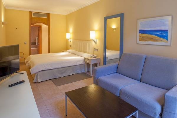 Hotelzimmer im IFA Altamarena mit Doppelbett, Fernseher, Couch und Nachttisch