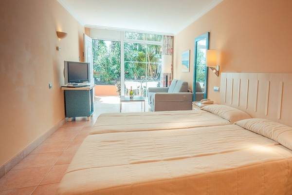 Doppelzimmer im IFA Altamarena Hotel mit zwei Betten, Fernseher, Couch und Fenstern