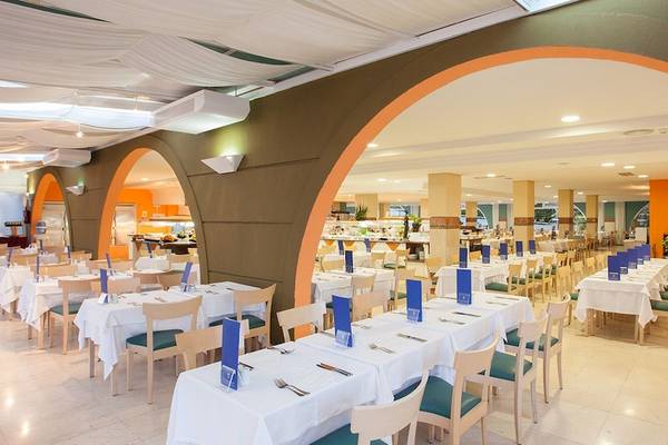 Innenbereich des Restaurants des IFA Altamarena by Lopesan Hotels mit gedeckten Tischen und Stühlen.