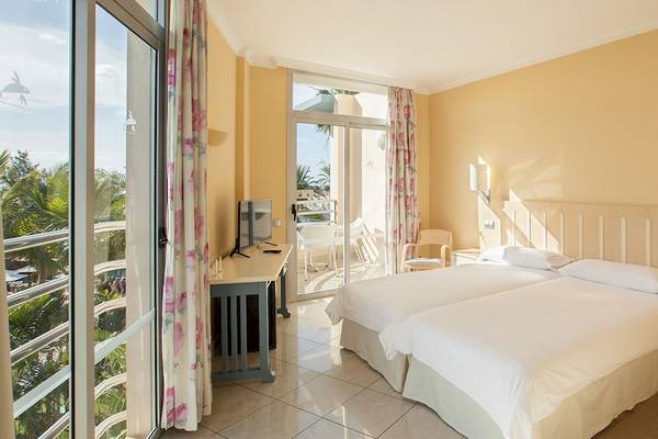 Doppelzimmer im IFA Altamarena Hotel mit Balkon, zwei Betten, Fernseher und Aussicht auf die Außenterrasse.