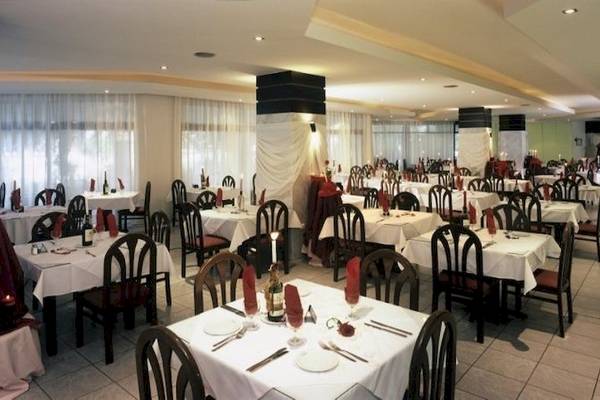 Innenansicht des Restaurants im Cathrin Hotel mit gedeckten Tischen und Stühlen.