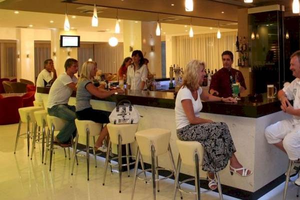 Mehrere Gäste sitzen an der Bar im Cathrin Hotel und unterhalten sich.