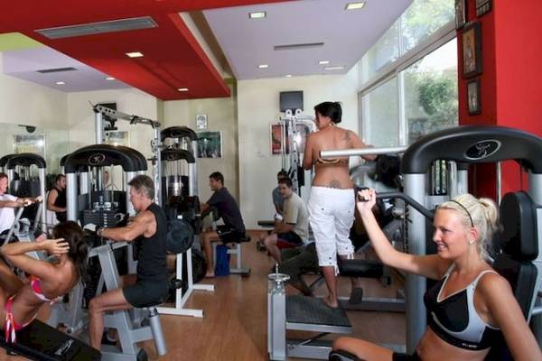 Fitnessstudio im Cathrin Hotel mit verschiedenen Geräten und trainierenden Personen.