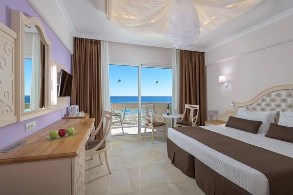 Innenansicht eines Zimmers im Rodos Palladium Leisure & Wellness Hotel mit Meerblick.