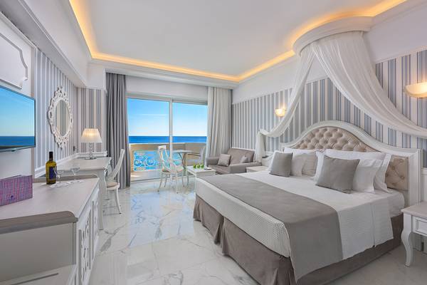 Ein elegantes Hotelzimmer im Rodos Palladium Leisure & Wellness mit Meerblick, modernem Design und komfortablen Möbeln.