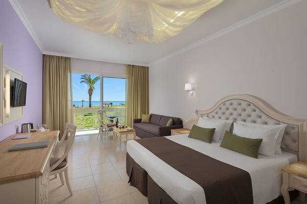 Hotelzimmer im Rodos Palladium Leisure & Wellness mit Blick auf das Meer und eine Palme.
