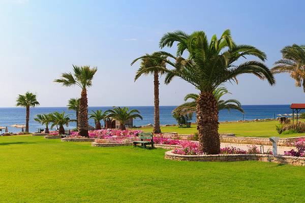 Gartenlandschaft des Rodos Palladium Hotels mit Palmen, Blumen und Meerblick