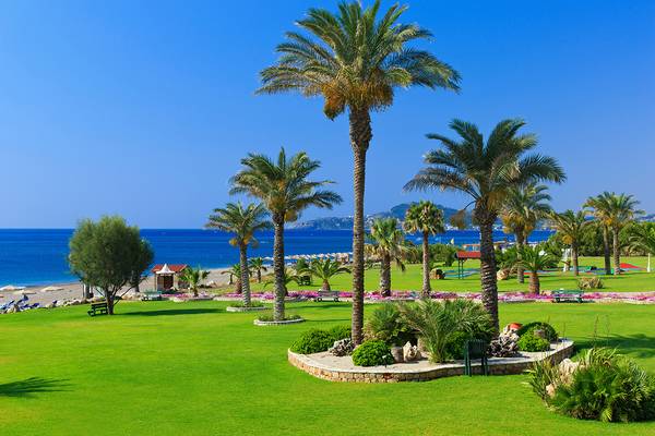 Park im Rodos Palladium Hotel mit Palmen und Blick auf den Ozean
