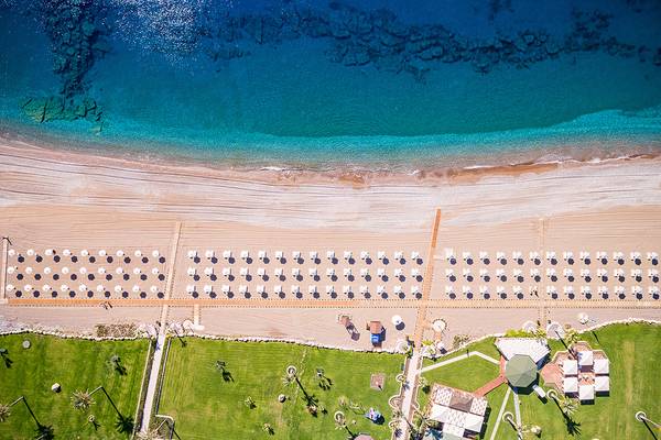 Luftaufnahme des Rodos Palladium Leisure & Wellness mit Blick auf den Strand und die Sonnenschirme.