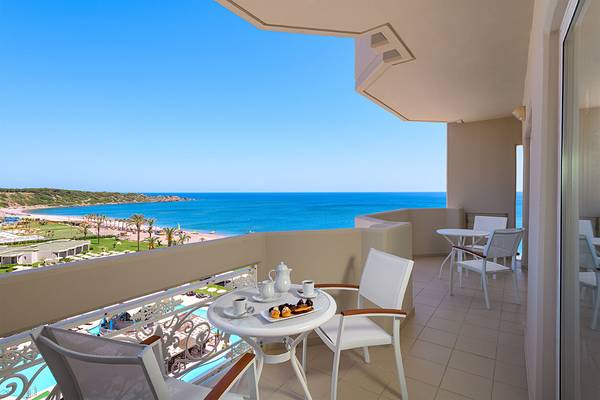 Hotelbalkon mit Blick auf das Meer und eine bewirtschte Tisch mit Kaffee und Kuchen.