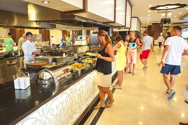 Mehrere Gäste bedienen sich an einem Buffet im Seaden Sea Planet Resort & Spa.