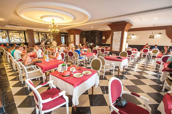 Innenansicht des Restaurants im Seaden Sea Planet Resort & Spa mit Gästen an Tischen.