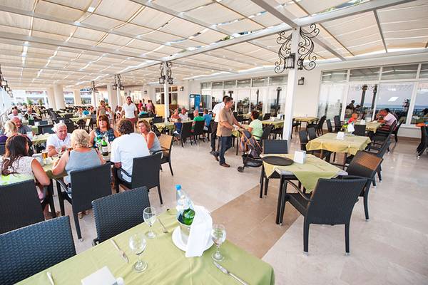 Terrasse des Seaden Sea Planet Resort & Spa mit Gästen an Tischen.