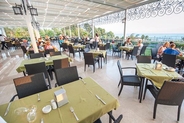 Gäste sitzen an Tischen in einem Terrassenrestaurant des Seaden Sea Planet Resort & Spa.