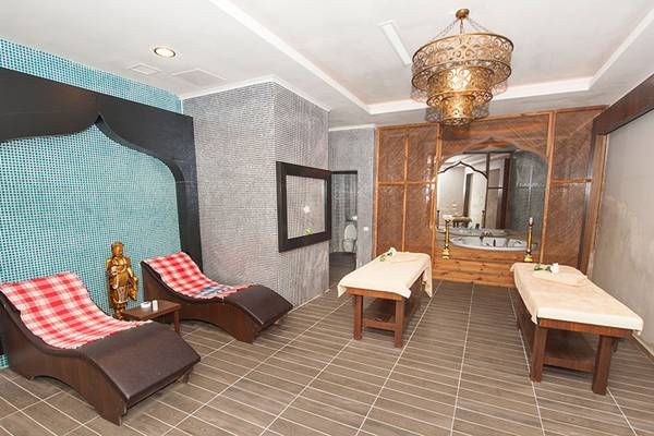 Massageraum im Seaden Sea Planet Resort & Spa mit zwei Liegen und zwei Massagetischen.
