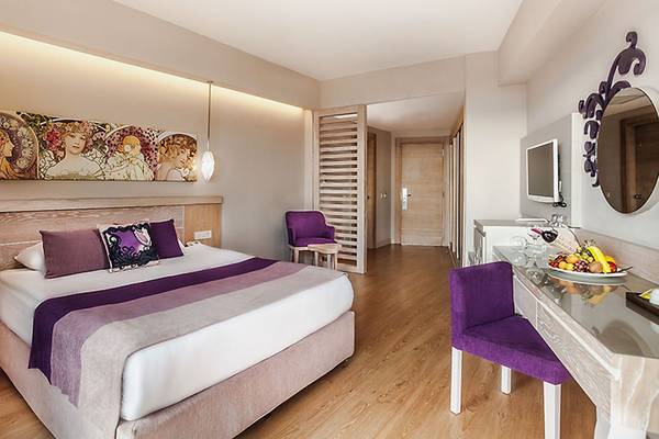 Hotelzimmer im Seaden Sea Planet Resort & Spa mit großem Bett, Kunstwerk an der Wand und moderner Einrichtung.