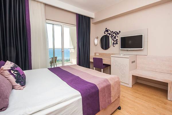 Hotelzimmer im Seaden Sea Planet Resort & Spa mit Meerblick, Bett, Schreibtisch, Fernseher und Möbeln.